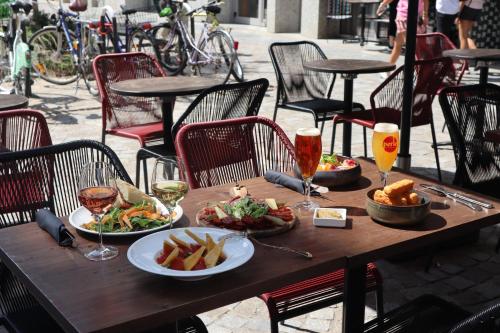 uma mesa de madeira com dois pratos de comida e bebidas em BOMA easy living hotel em Estrasburgo