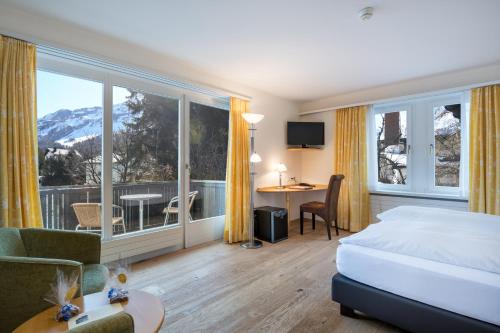 Habitación de hotel con cama y balcón en Schweizerhaus Swiss Quality Hotel en Maloja