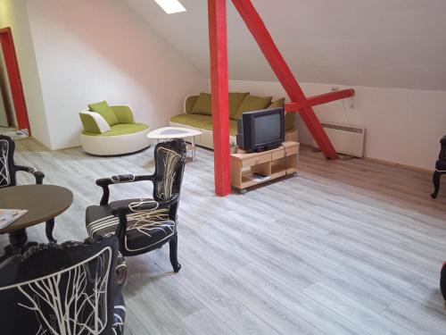 ein Wohnzimmer mit einem TV und einem Sofa in der Unterkunft LINDENHOF WALDHEIM in Waldheim