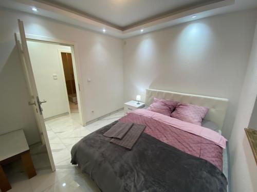 a bedroom with a large bed with purple pillows at Apartman Stivi Deluxs 2 in Vrnjačka Banja