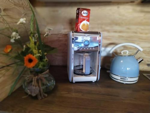 a toaster sitting on a table next to a vase with flowers at Naturstammhaus Tollensesee in Krickow