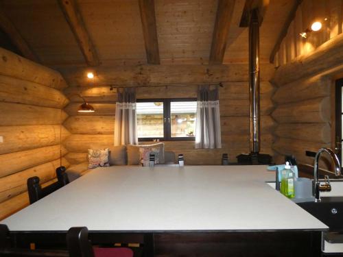 a large white table in a room with wooden walls at Naturstammhaus Tollensesee in Krickow