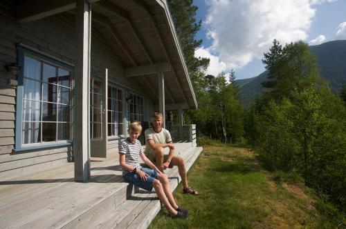 a man and a woman sitting on a porch of a house at Jølsterlia Hyttetun in Årdal