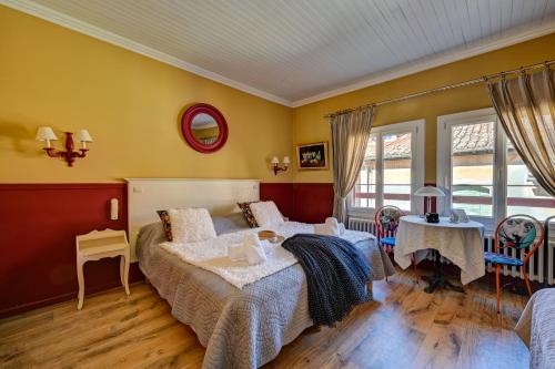 a bedroom with two beds and a table and chairs at Hotel Des Artistes in Tarascon