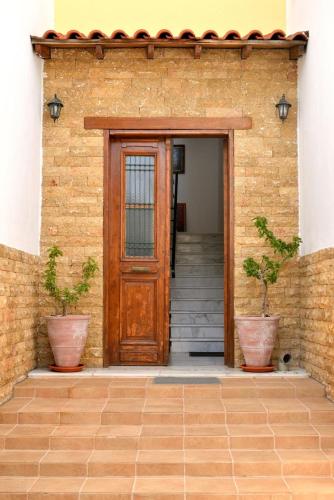 a house with a wooden door and two potted plants at Studio Nikiti Beach in Nikiti