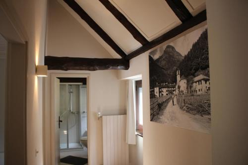 a bathroom with a painting on the wall at MyVerzasca Resort Casa Rossa in Brione