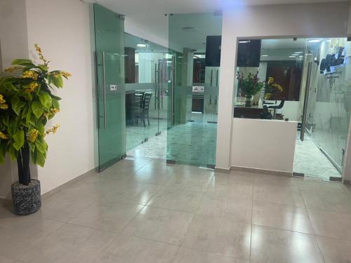 a lobby with glass walls and a potted plant at Hotel El Mirador in Ciudad Valles