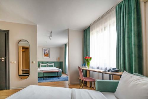 een hotelkamer met een bed en een spiegel bij Hotel H12**** in Krakau