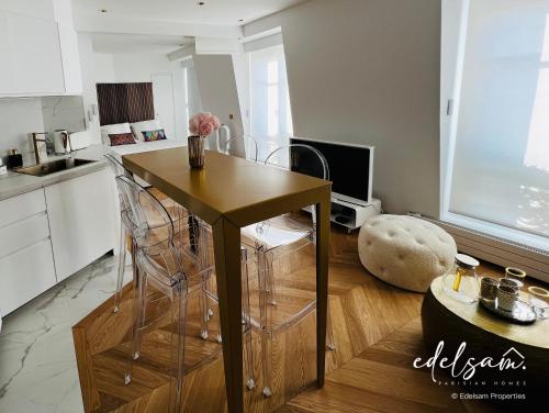 een keuken met een tafel en stoelen in een kamer bij Paris Parc Monceau by Edelsam in Parijs