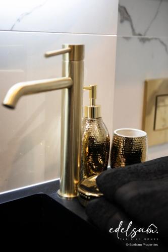 a sink with a faucet and a bottle of soap at Paris Parc Monceau by Melvane in Paris