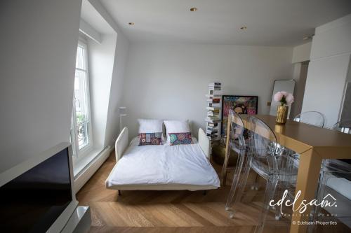 a room with a bed and a table and a kitchen at Paris Parc Monceau by Melvane in Paris