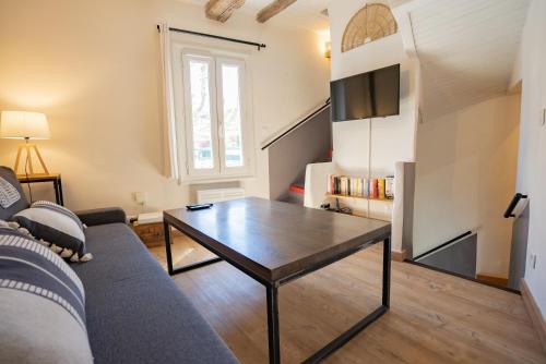 a living room with a couch and a table at Petite maison de charme au cœur du centre ville in Apt