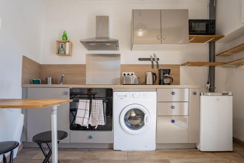 une cuisine avec une machine à laver et un lave-linge dans l'établissement Petite maison de charme au cœur du centre ville, à Apt