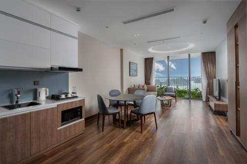 a kitchen and living room with a table and chairs at Flamingo Resort Cat Ba in Cat Ba