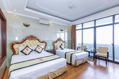 a hotel room with two beds and a window at Phuong Hoang Hotel in Thanh Hóa