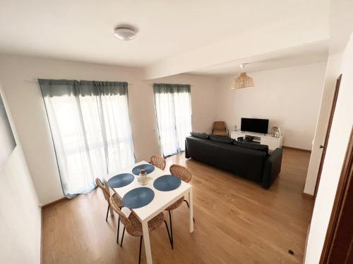 a living room with a table and a couch at Apartamento da Fonte in Figueira da Foz