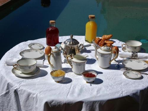 a table with a white table cloth with tea sets on it at CHATEAU LA SERVAYRIE - Chambre d'hôtes in Marcillac-Vallon