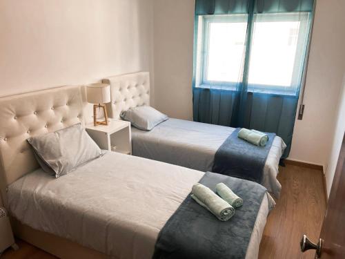 1 dormitorio con 2 camas y ventana en Apartamento da Fonte en Figueira da Foz