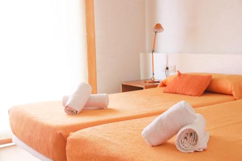 two beds in a room with towels on them at Villa Forma Nou in Mahón