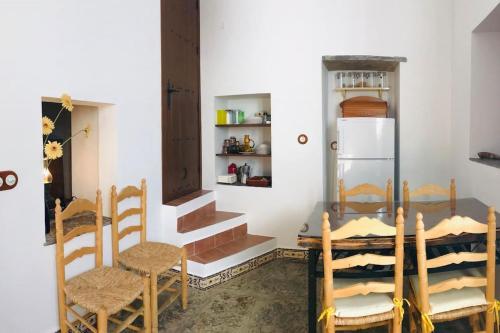 uma cozinha com uma mesa e cadeiras e um frigorífico em Casa Mora em Encinasola