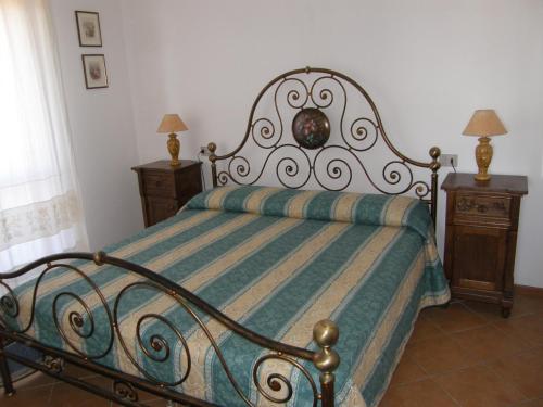 1 cama en un dormitorio con 2 mesitas de noche y 2 lámparas en Isola Rossa Appartamenti Bellavista en Isola Rossa