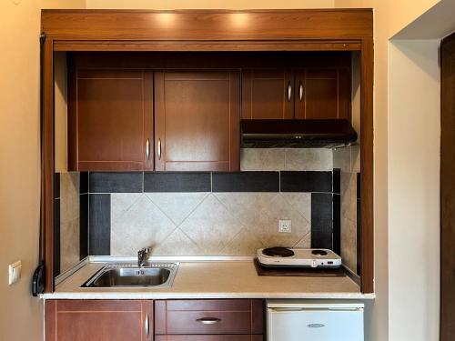 Una cocina con gabinetes de madera y un fregadero. en ADG Luxurious Apartments, en Leptokarya