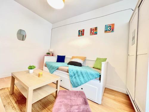 une petite chambre avec un lit et une table dans l'établissement L'Arizona, Studio à 5 minutes du centre-ville, à Poitiers
