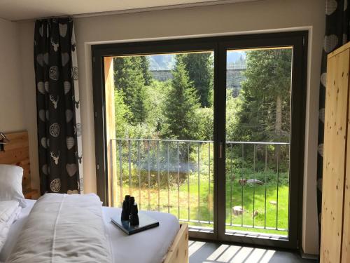 a bedroom with a bed and a large window at Berghotel Mettmen in Schwanden