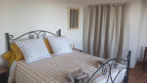 une chambre avec un lit avec une couverture à carreaux dans l'établissement chambre d'hôtes cotignac, à Cotignac