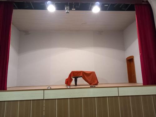 a room with a stage with a table and red curtains at LINDENHOF WALDHEIM in Waldheim