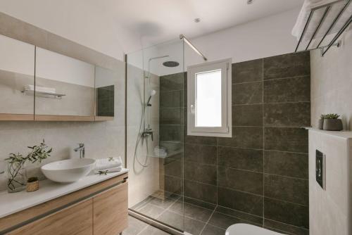 y baño con lavabo y ducha acristalada. en Summertime Villas, en Argostoli