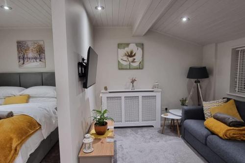 a bedroom with a bed and a couch at The Squirrels- Alresford, Essex in Alresford