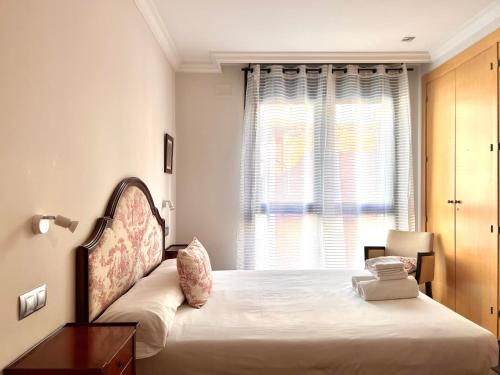 um quarto com uma cama grande e uma janela em Housingleón - Centro Colón em León
