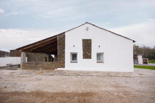 a white house with a brick at Apartamentos Lucio Rodinso in Castroverde