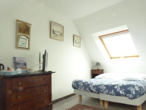a bedroom with a bed and a dresser and a window at Gite des confitures à Lanvéoc-Crozon in Lanvéoc