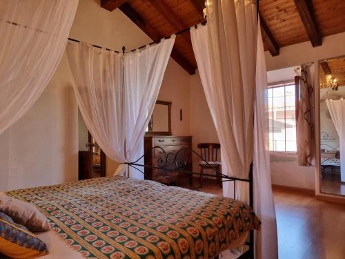 a bedroom with a bed with curtains in it at Villa Monte Rena in Budoni