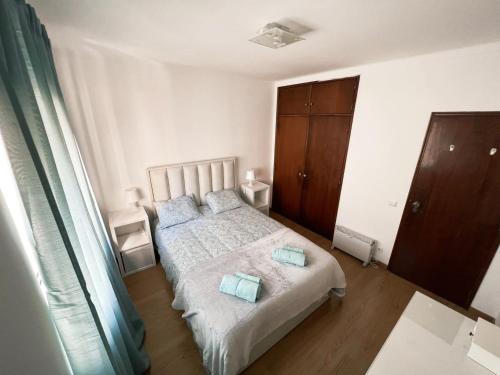 a bedroom with a bed with two pillows on it at Apartamento da Fonte in Figueira da Foz