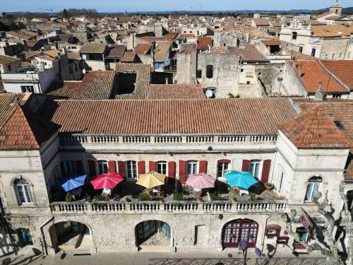 an old building with umbrellas in front of a city at Hotel Des Artistes in Tarascon