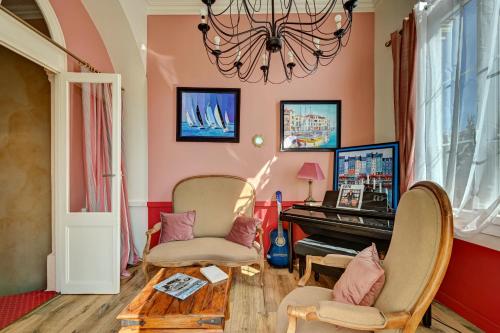 a living room with a piano and two chairs at Hotel Des Artistes in Tarascon