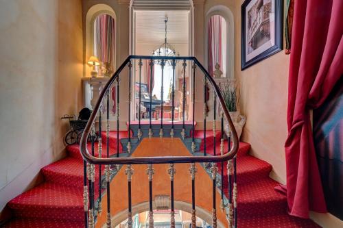 a staircase with a glass railing and red stairs at Hotel Des Artistes in Tarascon