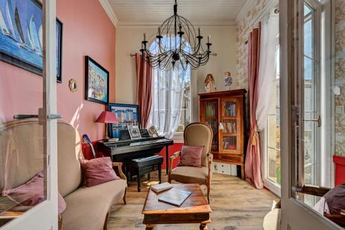 a living room with a piano and a chandelier at Hotel Des Artistes in Tarascon