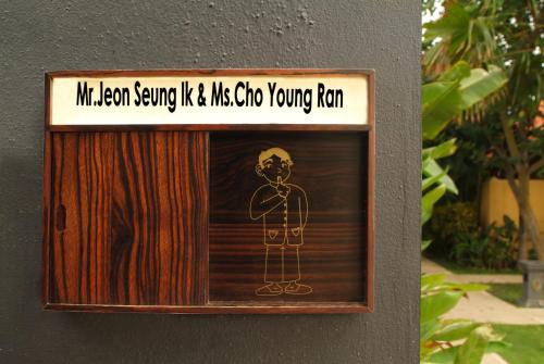 a sign on a wall with a drawing of a man at Alaya Dedaun Kuta in Legian