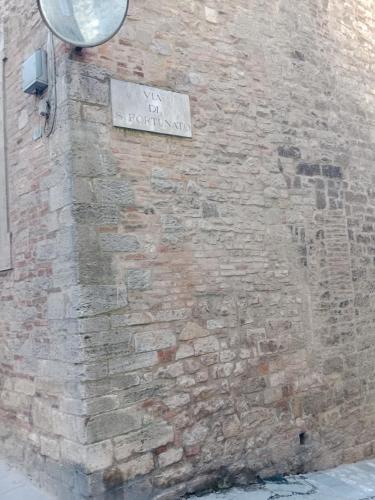 a brick wall with a street sign on it at Casa vacanza Todi Antica in Todi