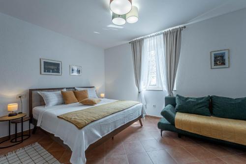 a bedroom with a bed and a couch at Ferienhaus/HolidayHouse Smokvica **** in Rakalj in Rakalj