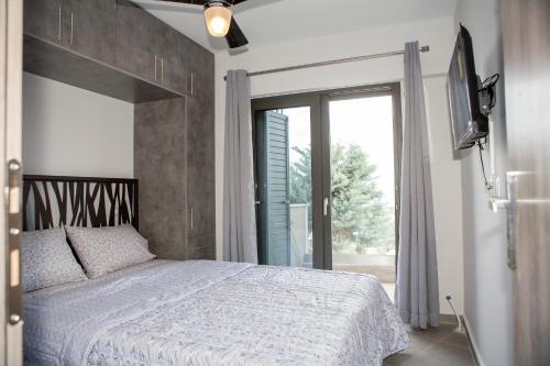 a bedroom with a bed and a large window at Sea View Frini Lefkada in Lefkada Town