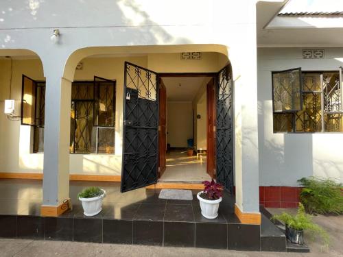 a front door of a house with two potted plants at Wonders Hostel in Arusha