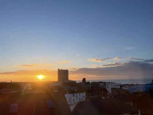 a sunset over a city with the sun in the sky at Coastal Comfort, Seaside Flat in Margate