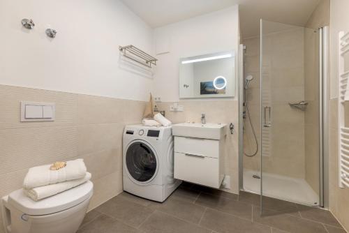 uma casa de banho com uma máquina de lavar roupa e uma máquina de lavar roupa. em Suite "Lycka" em Zingst