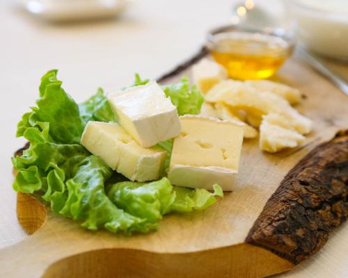a cutting board with cheese and lettuce on it at Hotel Stella Del Mare in Cervia