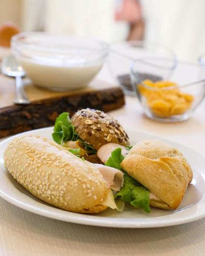 a white plate with two sandwiches on a table at Hotel Stella Del Mare in Cervia